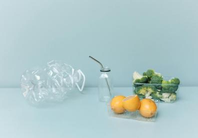 photo d'une bouteille en plastique vide, et deux barquettes de brocolis et oranges