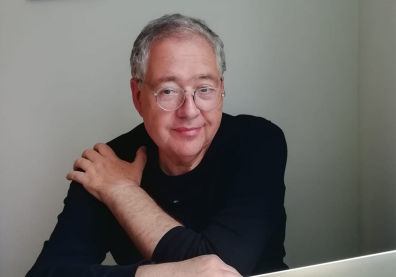 photo d'un homme à lunettes avec un pull noir