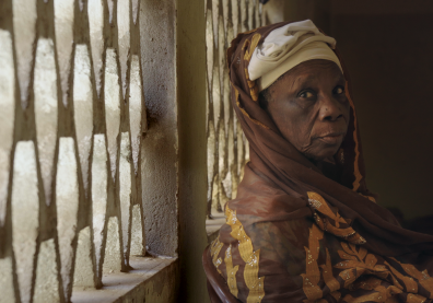 Une dame âgée vêtue d'un pagne est assise