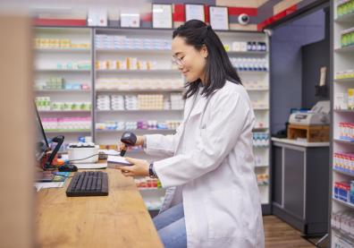 Young female pharmacist scanning medications