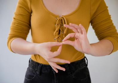 Gros plan sur le buste d'une femme qui fait le langage des signes
