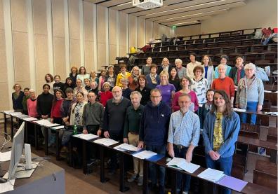 Un groupe de personnes debout sur les bancs de l'auditorium 