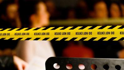 Photo d'un bandeau noir et jaune en premier plan et plusieurs personnes floues en arrière plan