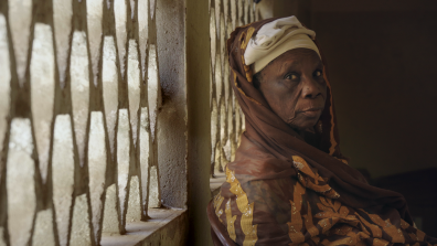 Une dame âgée vêtue d'un pagne est assise
