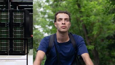 A young man stands in front of a tree