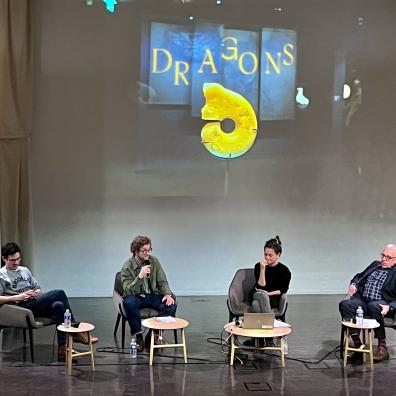 Une scène sur laquelle se trouvent 4 personnes assises micro à la main et discutent 