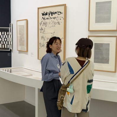 A doctoral student talks to a visitor about her research at the museum