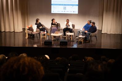 Plusieurs intervenants discutent sur la scène de l'auditorium