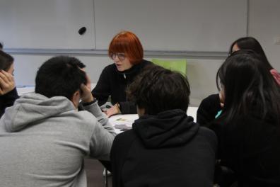 Une femme enseigne à des étudiants autour d'une table