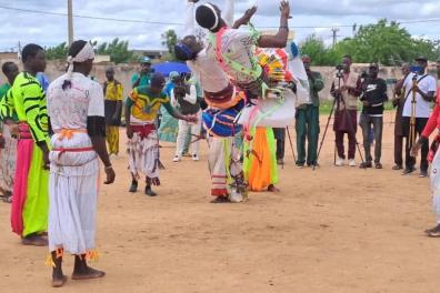 Des hommes réalisant des figures acrobatiques habillés avec des couleurs vives 