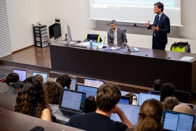 Jean-François Huchet, debout à côté de David Bertolotti, s'exprime devant un amphithéâtre rempli d'étudiants qui l'écoutent