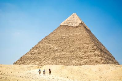 Les gens à dos de chameau près de La pyramide sous le ciel bleu, Gizeh, Egypte