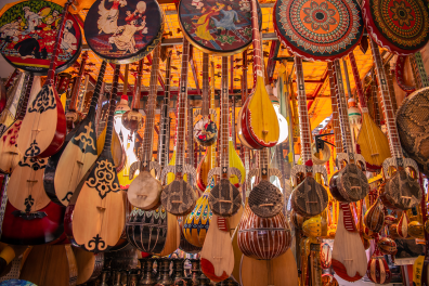 Instruments traditionnels ouïghours suspendus sur le stand d'un grand marché 