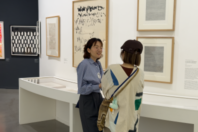 A doctoral student talks to a visitor about her research at the museum
