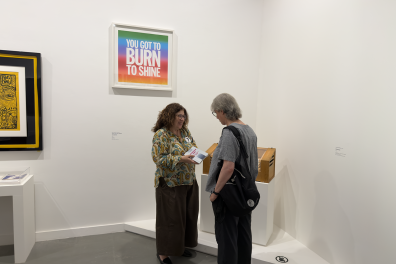 A woman gives explanations to a museum visitor