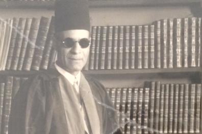 Taha Hussein devant sa biblothèque dans son bureau