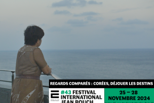 Une femme aux cheveux cours de dos regarde la mer au loin