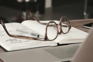 des lunettes de vue posées sur un cahier