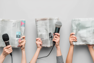 Des mains féminines avec des journaux et des microphones sur un fond clair