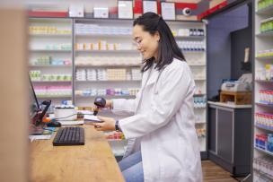 Jeune pharmacienne scannant des médicaments