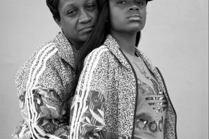 Portrait de deux femmes, la maman prend dans ses bras sa fille de dos