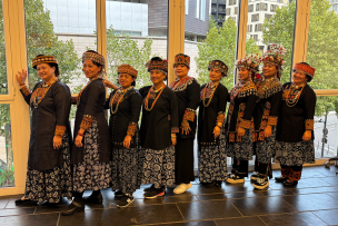10 personnes à la queue leu-leu en tenue traditionnelle 