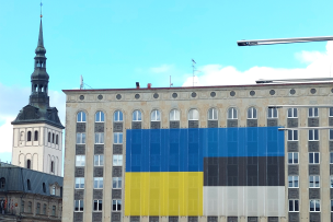 Un immeuble avec deux drapeaux accrochés et sur la gauche un clocher